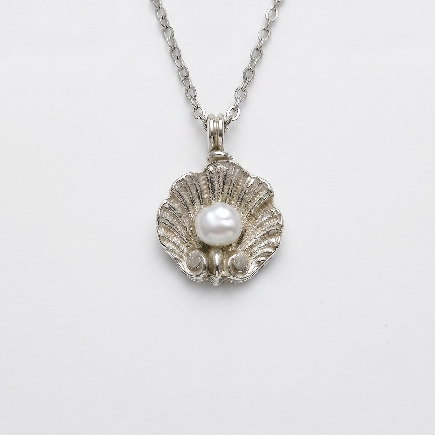 Pendente DEIDDA a conchiglia scanalata in argento con perla naturale, gioiello fatto a mano in Italia.