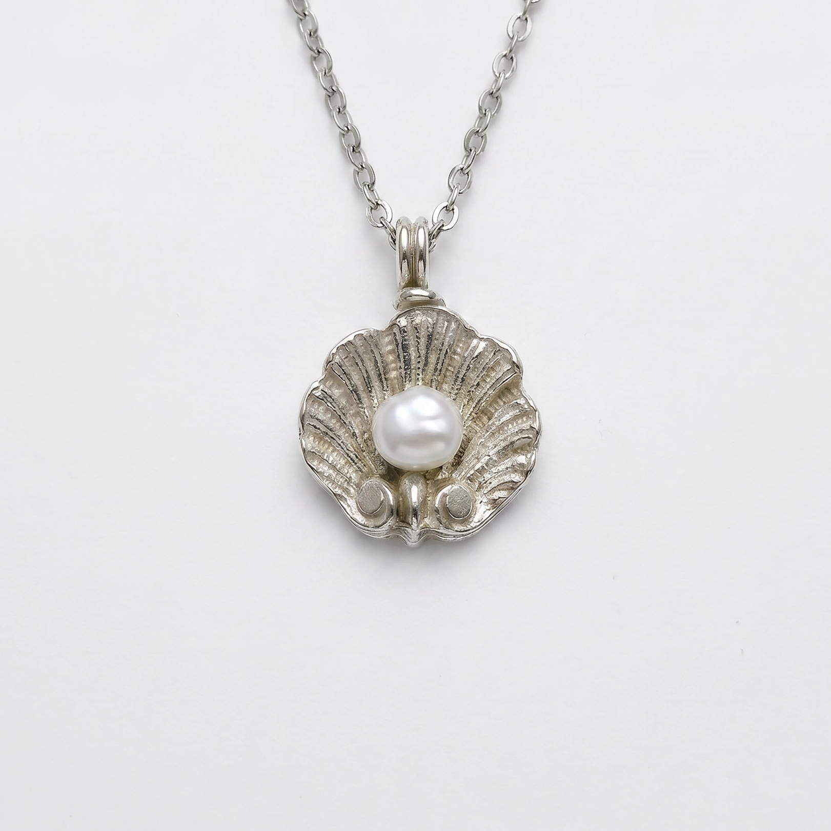 Pendente DEIDDA a conchiglia scanalata in argento con perla naturale, gioiello fatto a mano in Italia.
