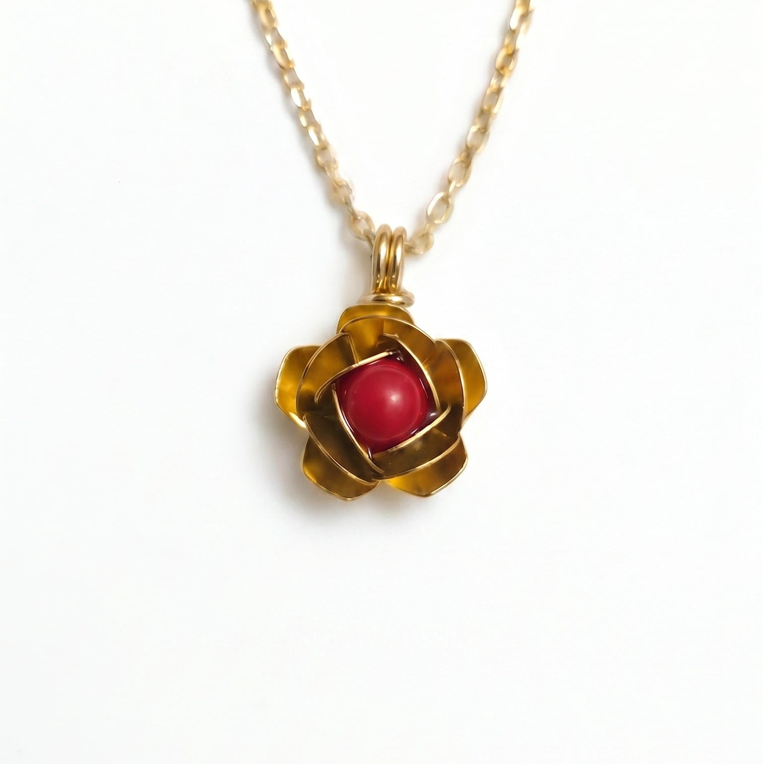 Collana artigianale in argento e bronzo bagnato in oro con pendente a forma di rosa e corallo rosso centrale
